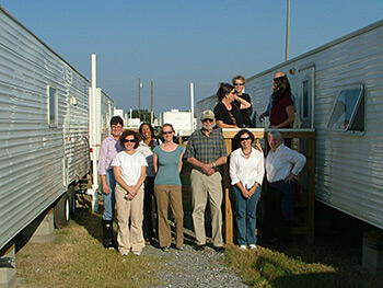 Displaced project researchers visiting a displaced University of New Orleans scholar's FEMA trailer, New Orleans, Louisiana, 2005. Lynn Weber is furthest to the left. Displaced project researchers visiting a displaced University of New Orleans scholar's FEMA trailer, New Orleans, Louisiana, 2005. Lynn Weber is furthest to the left.
