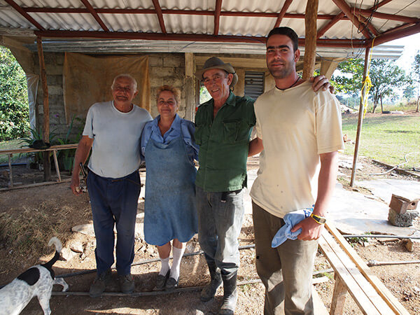 Maria and Augostín (in hat) with their only son Royber and Maria's brother, a neighboring farmer, pictured on the patio at their farm. Pinar del Rio, Cuba, January 2011.