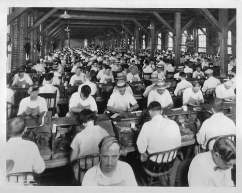 Burgert Brothers, Lector on raised platform reading to cigar workers at Corral Wodiska factory, Tampa, Florida, 1929. Catalog No.: PA 5390.