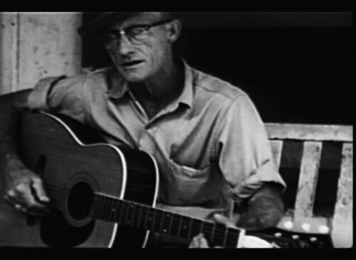 Roscoe Halcomb playing guitar on his front porch in The High Lonesome Sound