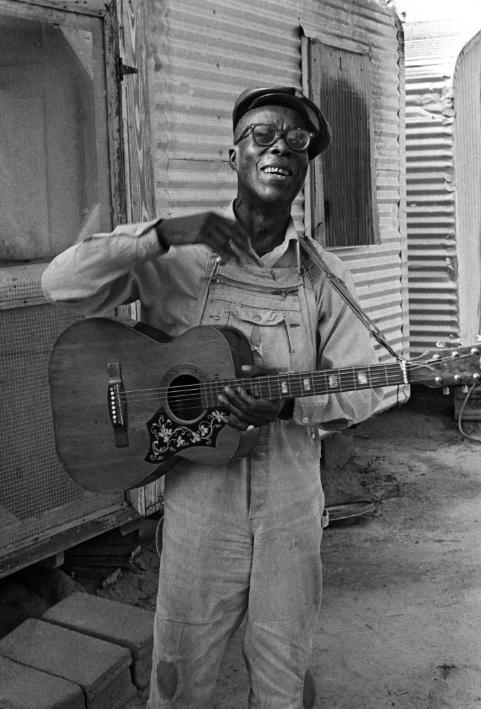 Lonzie Thomas holding a guitar.