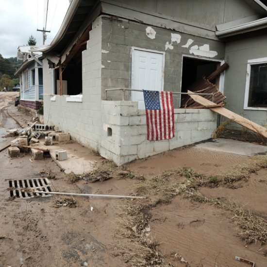 Flooded former Farm Bureau Insurance business with American flag, Main Street, Marshall, North Carolina, on the day after the flood from Hurricane Helene.